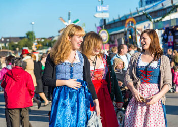 Munich, Germany - October 01, 2013: Young Girls at the Oktoberfest in Munich (Germany). They are wearing typical dirndl - the traditional bavarian clothing. The Oktoberfest is the biggest beer festival of the world with over 6 million visitors each year.