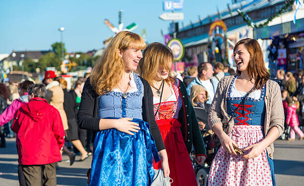 Munich, Germany - October 01, 2013: Young Girls at the Oktoberfest in Munich (Germany). They are wearing typical dirndl - the traditional bavarian clothing. The Oktoberfest is the biggest beer festival of the world with over 6 million visitors each year.